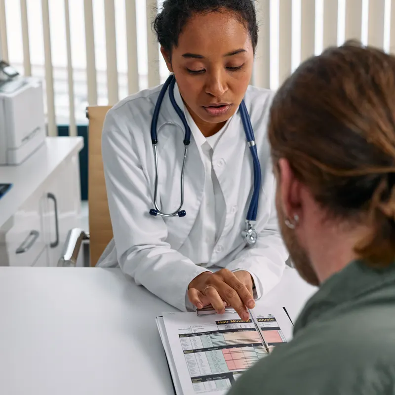 Eine Ärztin zeigt einem Patienten während einer Sprechstunde ein Dokument